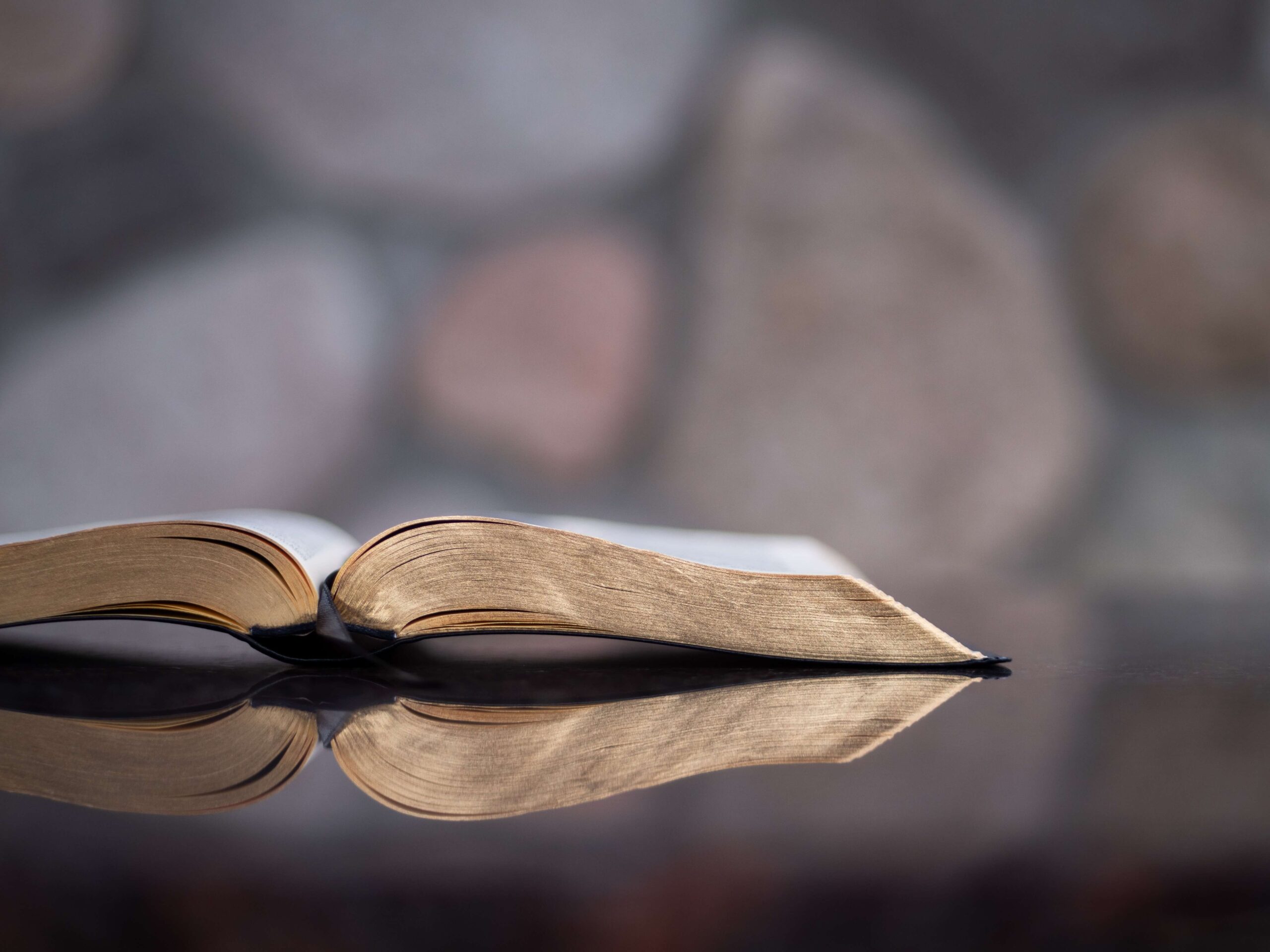 A gold rimmed Bible sits on a surface with a reflection. Our Christian counselors are able to provide services to people wanting to integrate faith into mental health in Raleigh NC!